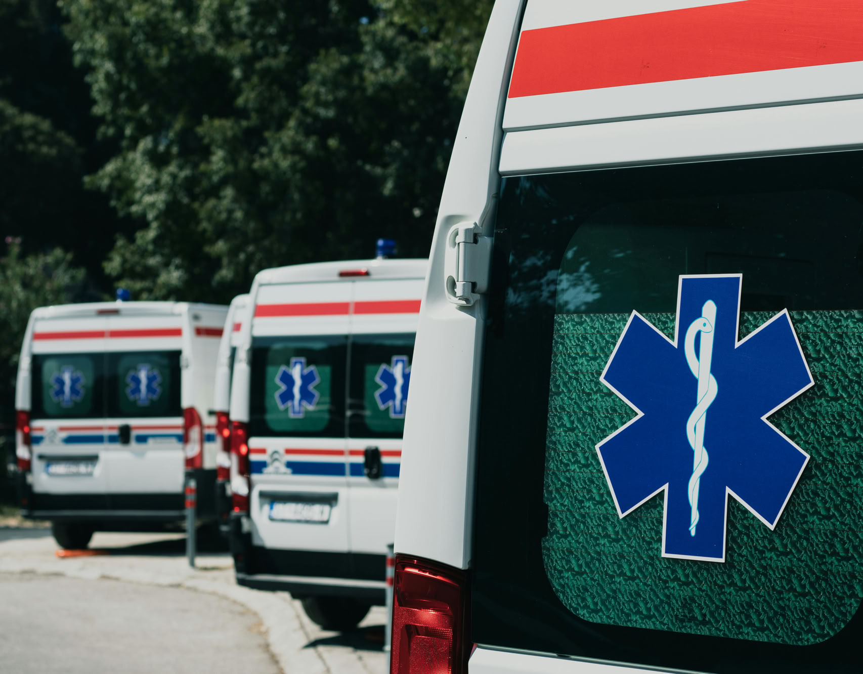 Three ambulances parked outdoors, ready for emergency healthcare situations.